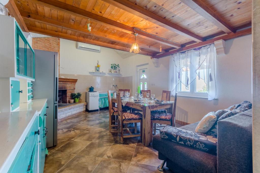 Dnevni boravak sa stropom od borovih greda i tirkiznom kuhinjom